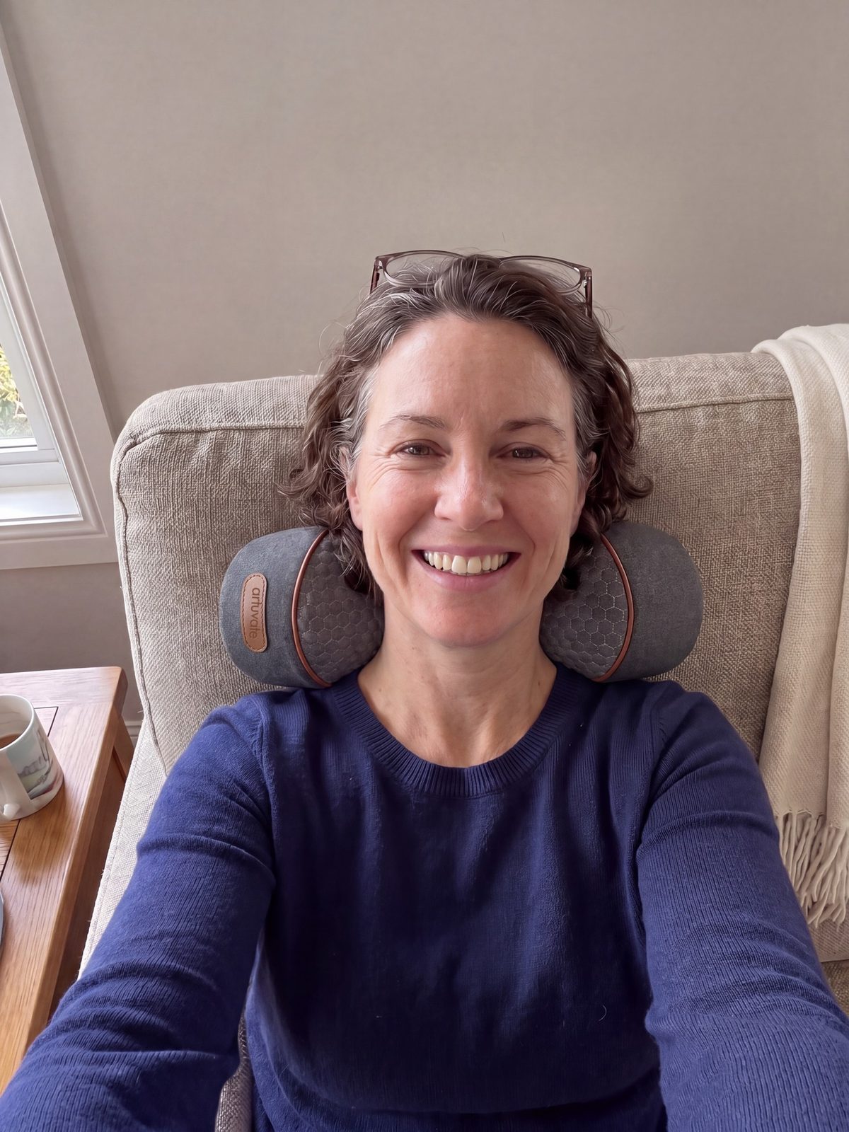 A woman smiling as she rests her head back on FisioRest in her armchair.