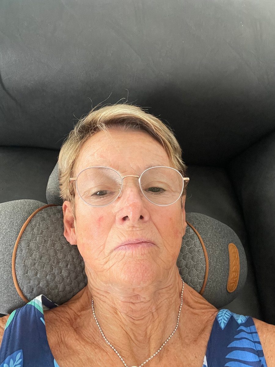 A FisioRest customer lying back with the device behind her neck.