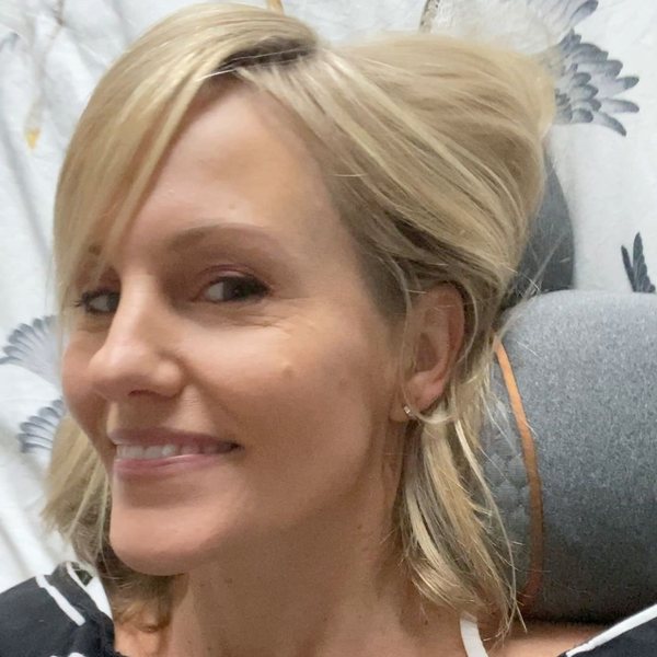 Laura, a customer, smiling with the device behind her neck.